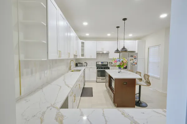 a kitchen with a sink a counter top space stainless steel appliances and cabinets