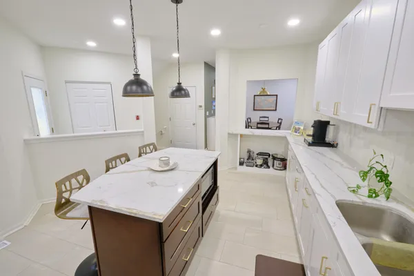 a large kitchen with kitchen island a sink stainless steel appliances and cabinets