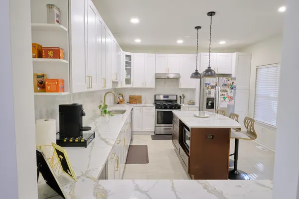 a kitchen with a sink refrigerator and microwave