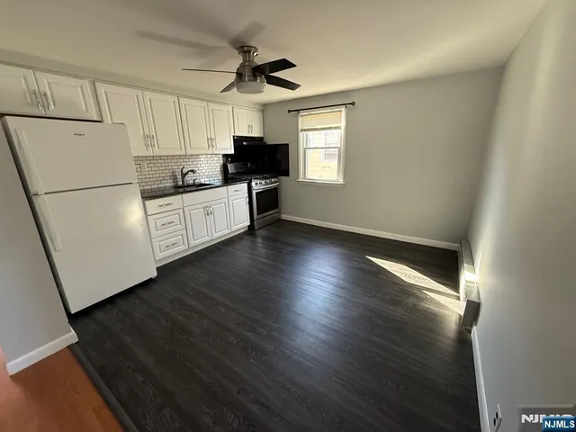 a kitchen with granite countertop white cabinets and white appliances