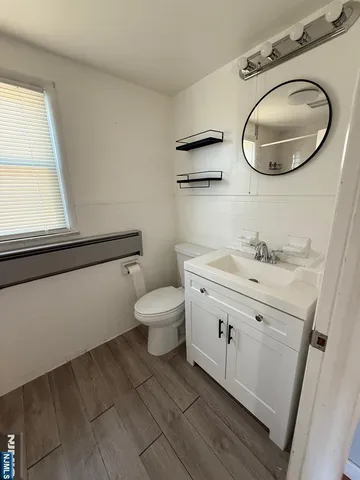 a bathroom with a granite countertop toilet sink and mirror
