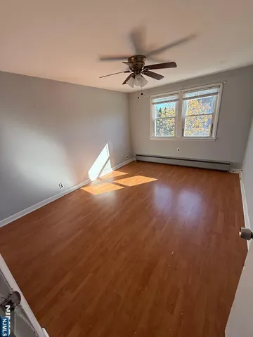 en empty room with windows and ceiling fan