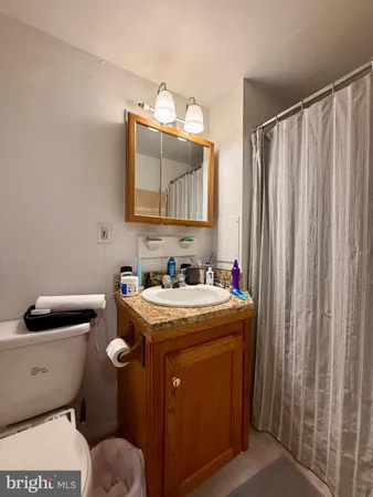 a bathroom with a granite countertop toilet sink and mirror