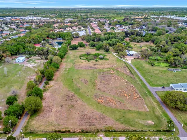 an aerial view of residential houses with outdoor space and trees