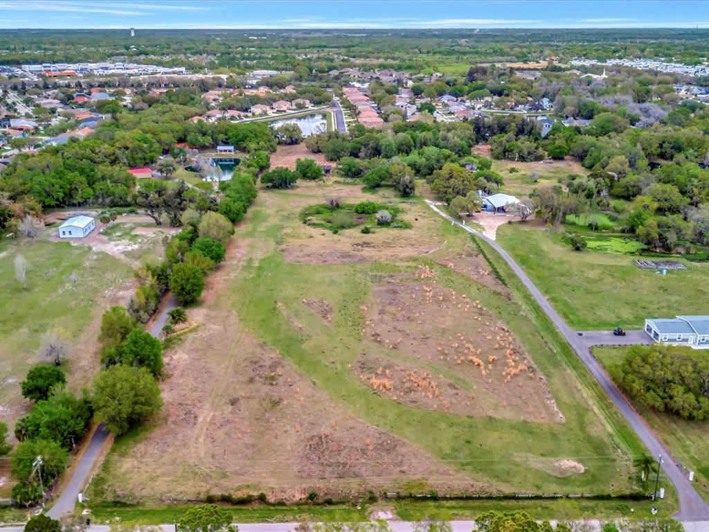 an aerial view of residential houses with outdoor space and trees