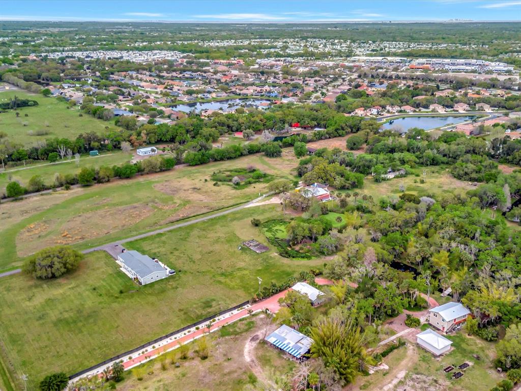 9120 25th Street East Parrish, FL 34219 - Photo 9 of 28 an aerial view of a residential houses covered in trees