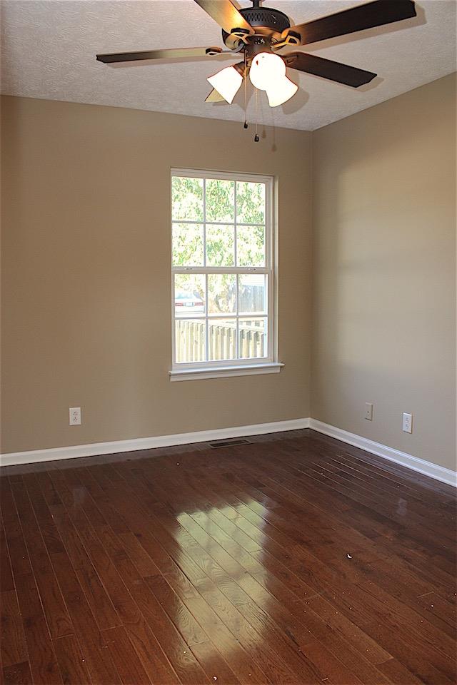 327 Bandera Lane Springfield, TN 37172 - Photo 8 of 11 an empty room with wooden floor chandelier fan and windows