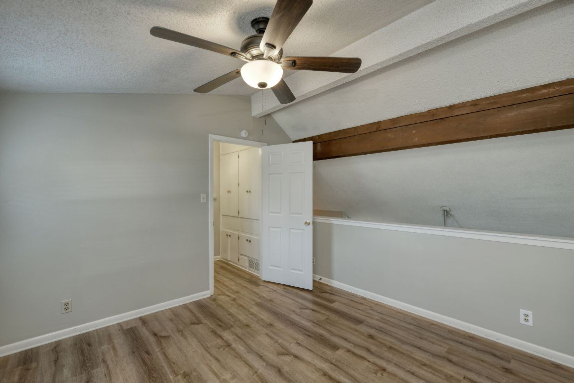 2711 St Edwards Circle, Unit 2 Austin, TX 78704 - Photo 12 of 17 Unfurnished bedroom featuring wood finished floors, a textured ceiling, and ceiling fan