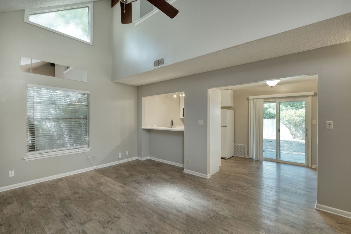 2711 St Edwards Circle, Unit 2 Austin, TX 78704 - Photo 5 of 17 Unfurnished living room with a high ceiling, wood finished floors, and a ceiling fan