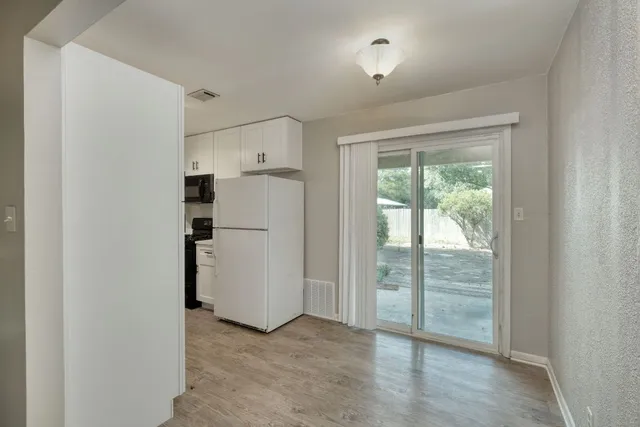 a view of empty room with wooden floor and window