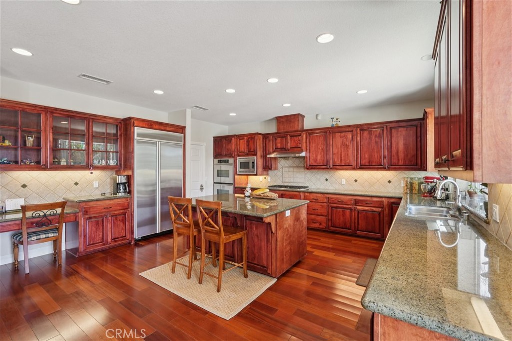 30810 Avenida Del Reposo Temecula, CA 92591 - Photo 11 of 75 a kitchen with stainless steel appliances granite countertop a stove top oven a sink dishwasher and cabinets with wooden floor
