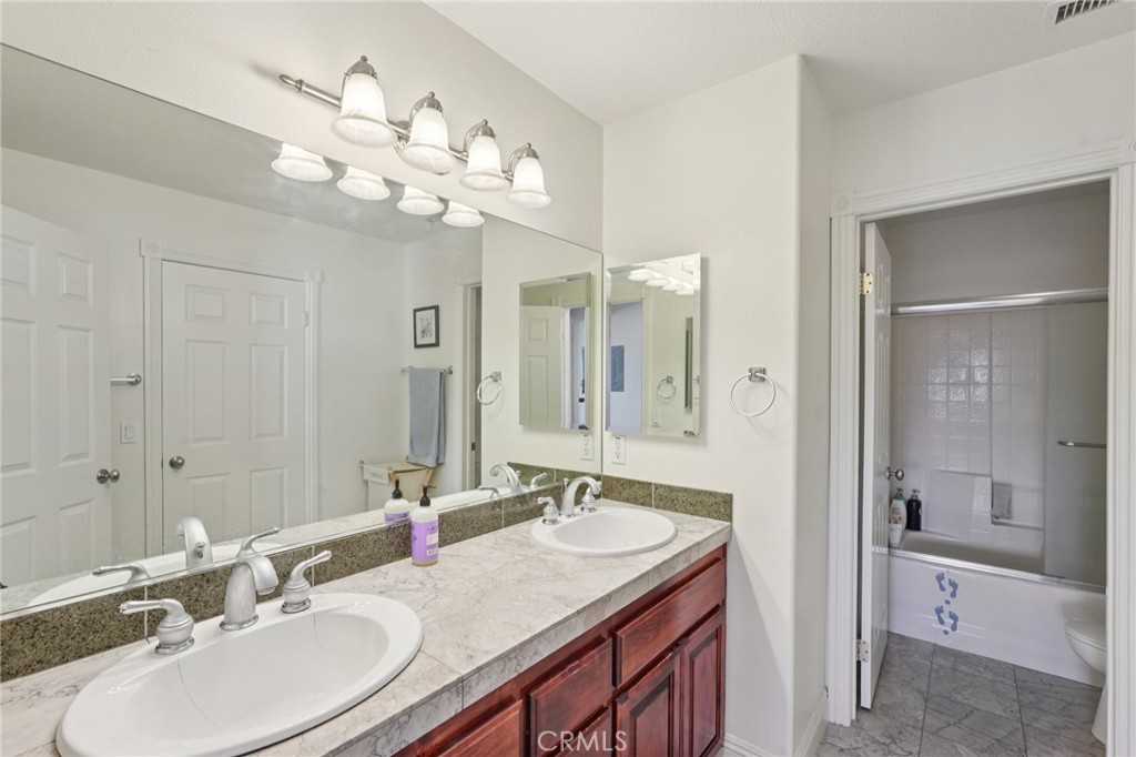 30810 Avenida Del Reposo Temecula, CA 92591 - Photo 24 of 75 a bathroom with a granite countertop sink a large mirror and a shower