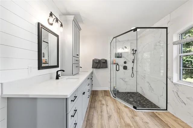 a bathroom with a double vanity sink mirror and shower