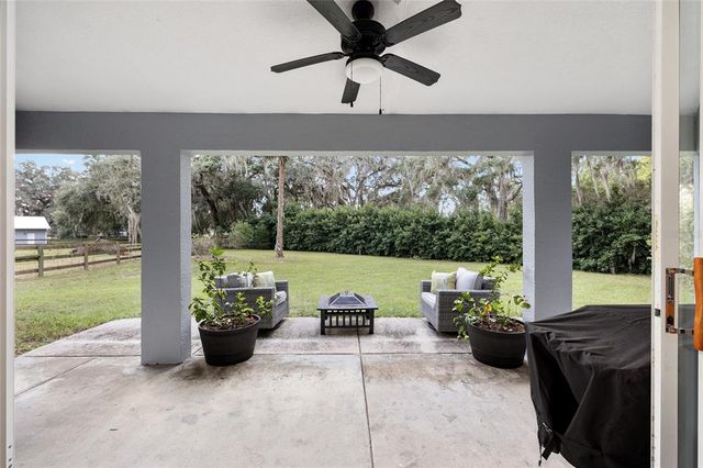 a living room with patio furniture and a garden