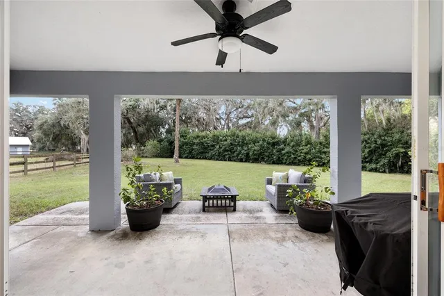 a living room with patio furniture and a garden