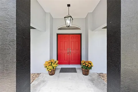 a view of a house with a yard and large tree