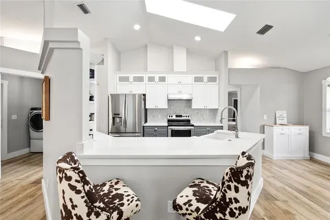 a kitchen with stainless steel appliances a stove a sink and a refrigerator