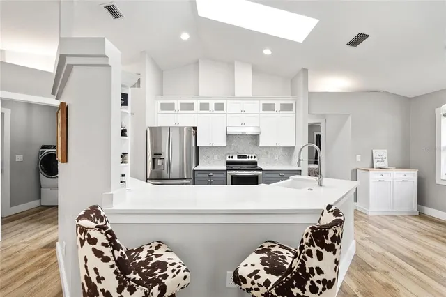 a kitchen with stainless steel appliances a stove a sink and a refrigerator