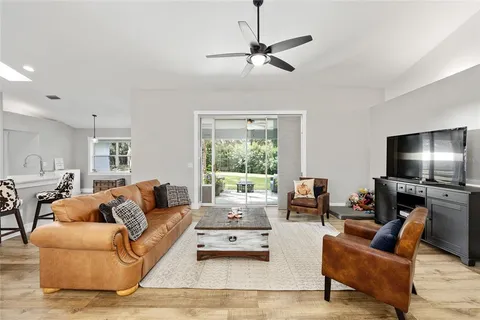 a living room with furniture flat screen tv and a large window