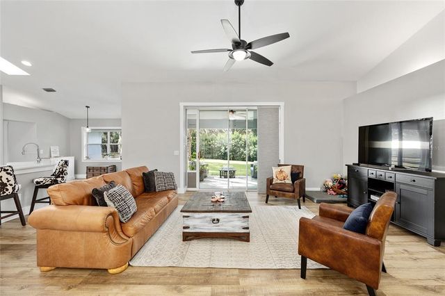 a living room with furniture flat screen tv and a large window