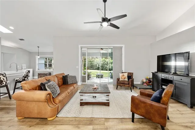 a living room with furniture flat screen tv and a large window