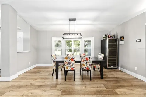 a dining room with furniture window and wooden floor