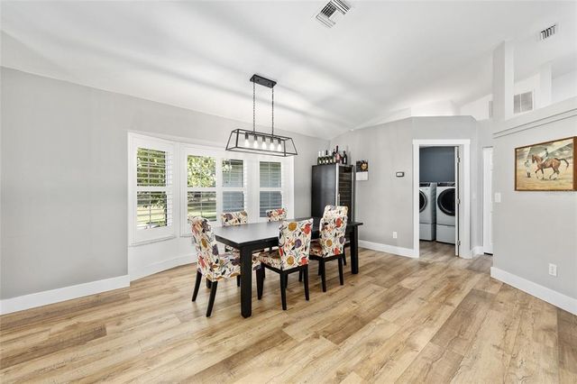a dining room with furniture a chandelier and wooden floor