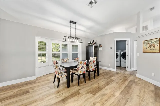 a dining room with furniture a chandelier and wooden floor
