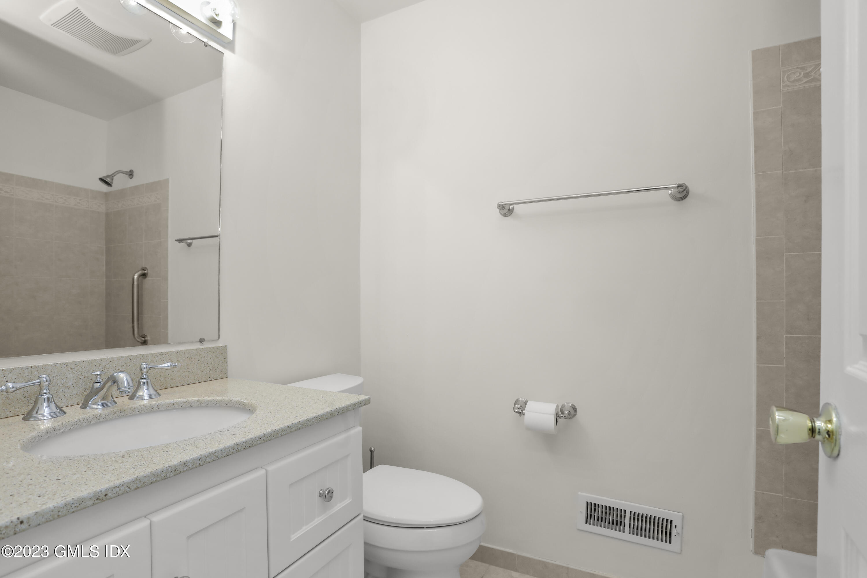 5 Glen Street, Unit 101 Greenwich, CT 06830 - Photo 19 of 37 a bathroom with a granite countertop sink mirror vanity and toilet