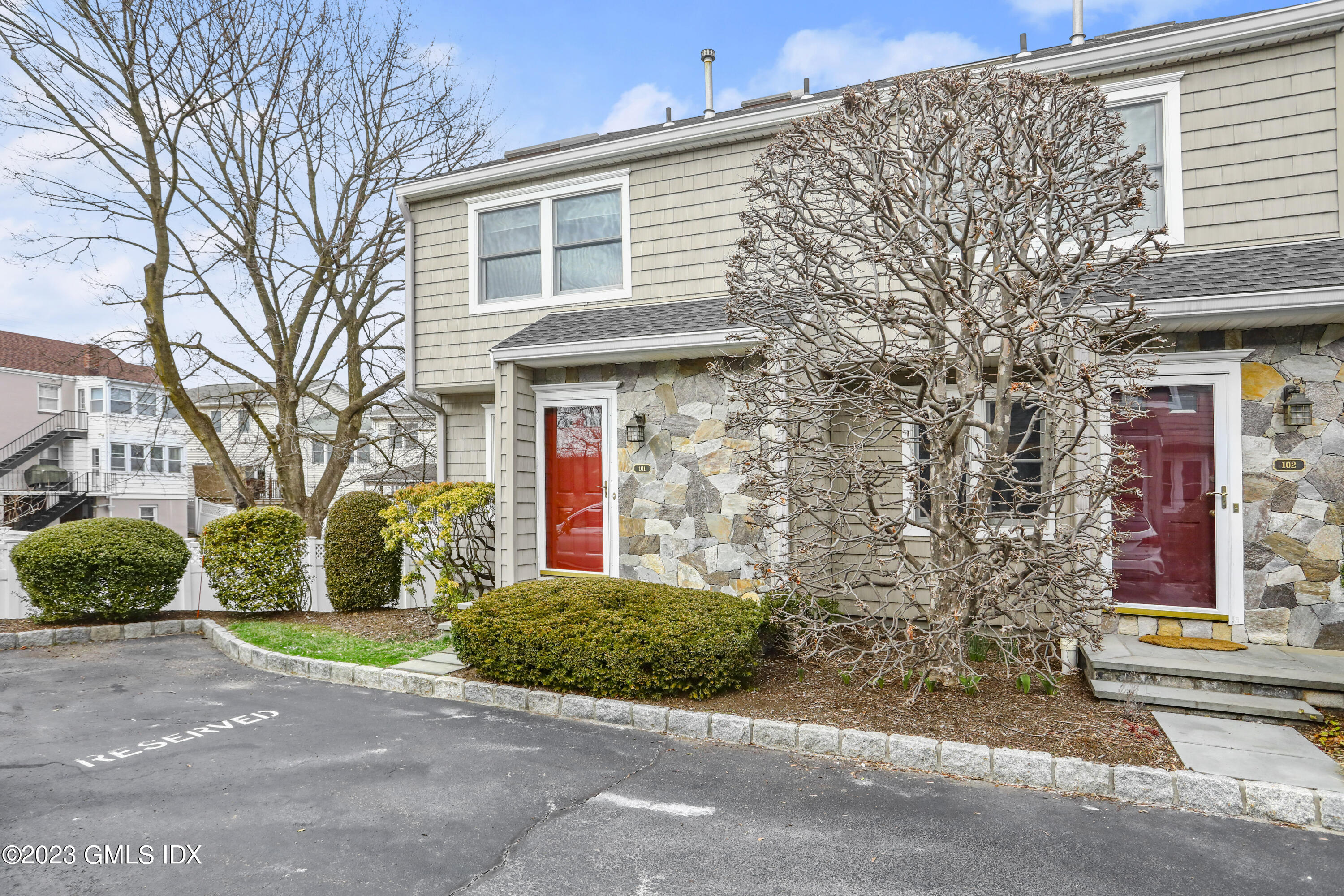 5 Glen Street, Unit 101 Greenwich, CT 06830 - Photo 28 of 37 a front view of a house with a garden