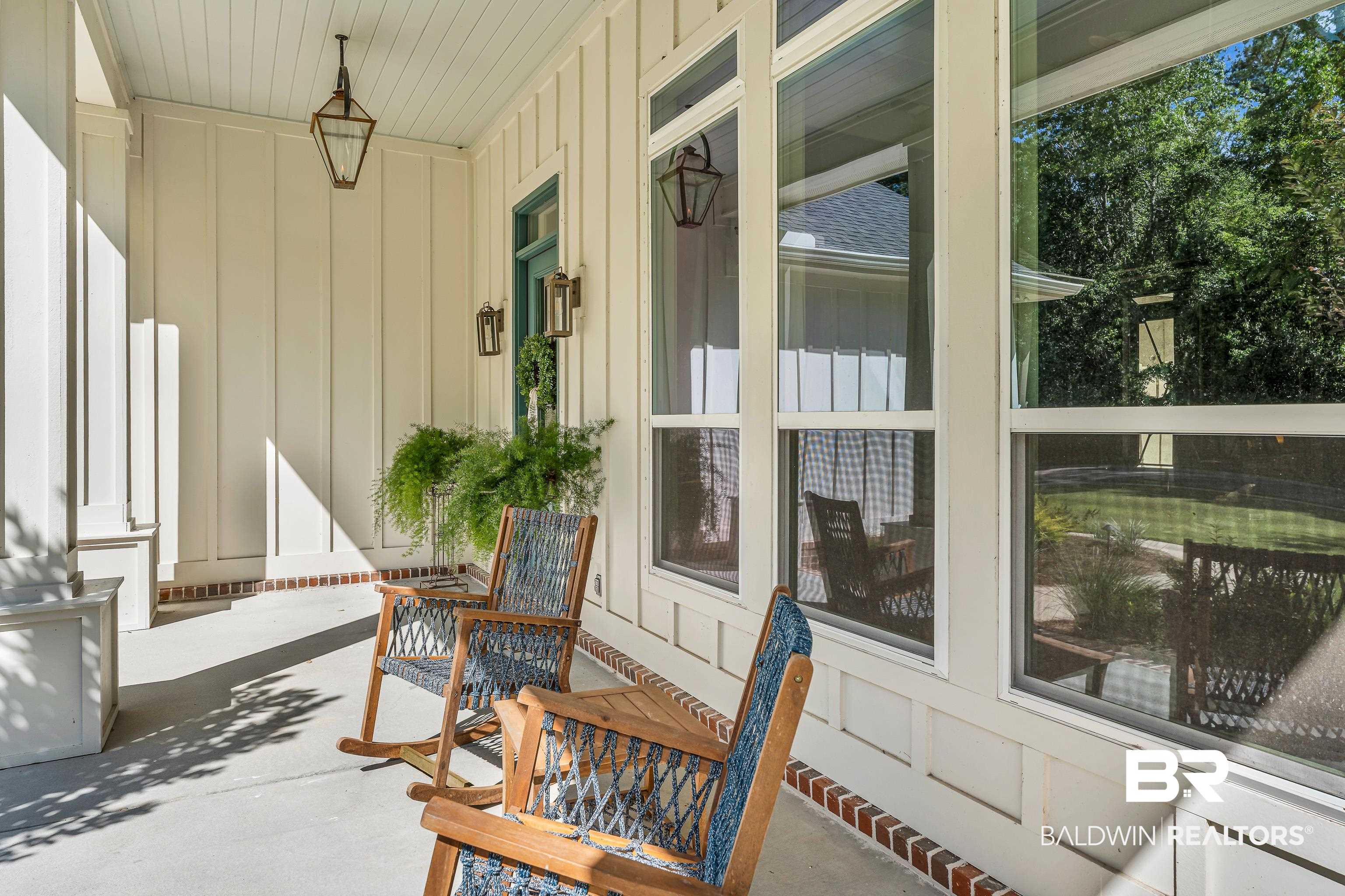 17541 Polo Ridge Boulevard Fairhope, AL 36532 - Photo 17 of 19 Covered porch featuring beadboard ceiling, board and batten siding, brick foundation trim, and large windows