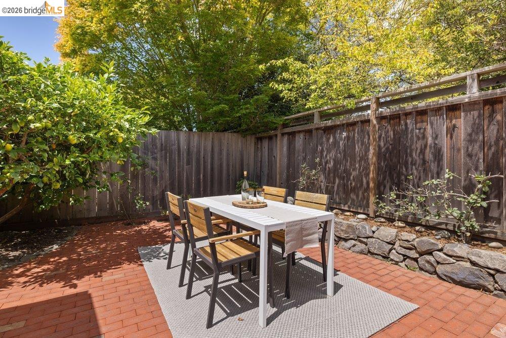 287 Purdue Avenue Kensington, CA 94708 - Photo 34 of 60 Private outdoor patio featuring brick pavers, a wood privacy fence, and a stone retaining wall