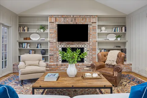 a living room with furniture a flat screen tv and a fireplace