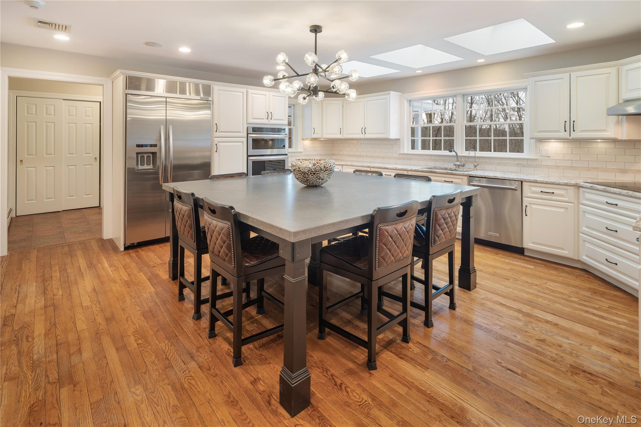 14 Adams Farm Road Katonah, NY 10536 - Photo 17 of 47 Eat-in kitchen with stainless steel appliances including new KitchenAid dishwasher, Electrolux 5 burner induction cooktop, KitchenAid convection wall oven and microwave convection oven, KitchenAid side-by-side refrigerator with in-door water/ice service, new 10 ft concrete topped center island seats 8