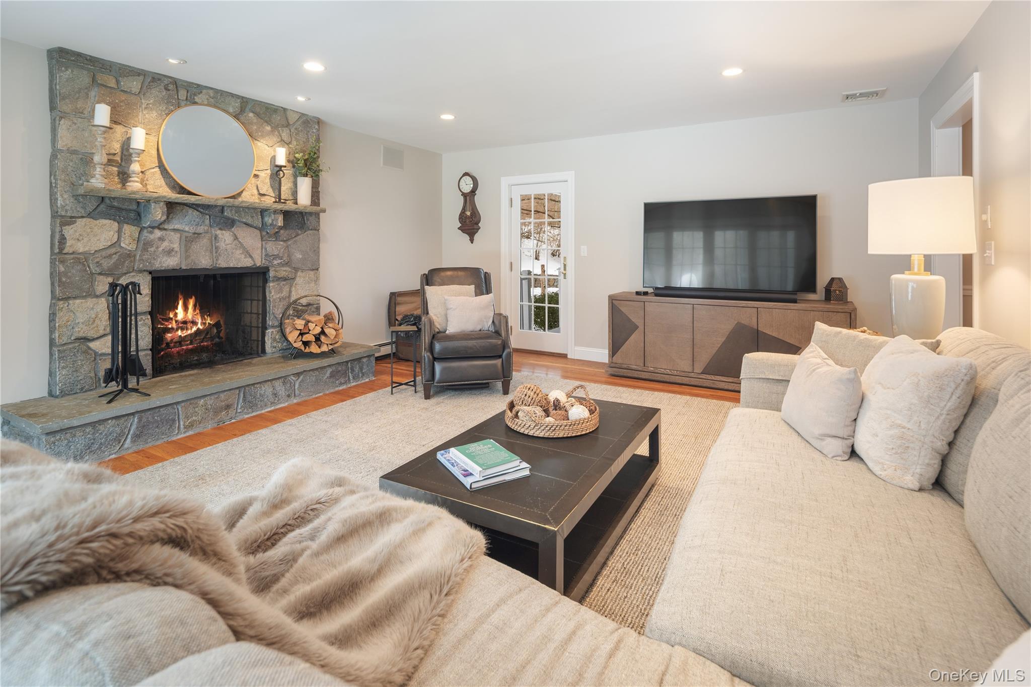 14 Adams Farm Road Katonah, NY 10536 - Photo 21 of 47 Gracious family room with door to front porch, sliding French doors to back deck, and raised hearthstone fireplace, oak floors, recessed lighting