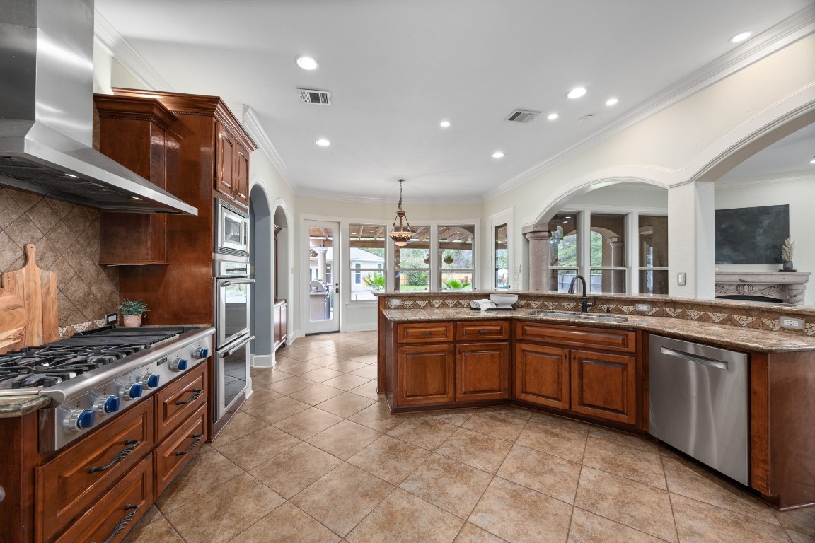 4447 Chateau Creek Way Spring, TX 77386 - Photo 15 of 50 a large kitchen with stainless steel appliances and a stove