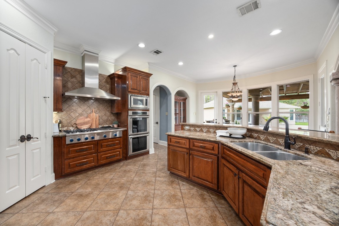 4447 Chateau Creek Way Spring, TX 77386 - Photo 16 of 50 a large kitchen with stainless steel appliances granite countertop a stove and a sink
