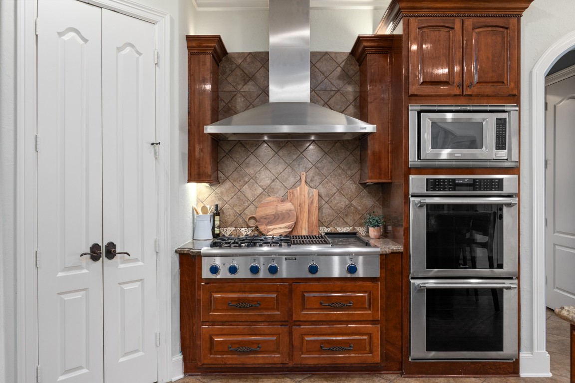4447 Chateau Creek Way Spring, TX 77386 - Photo 17 of 50 a kitchen with stainless steel appliances granite countertop a stove and a microwave