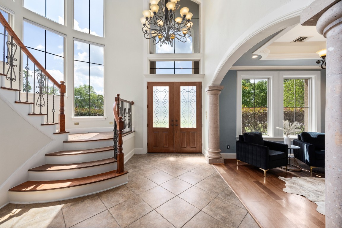 4447 Chateau Creek Way Spring, TX 77386 - Photo 8 of 50 a living room with large windows and a chandelier