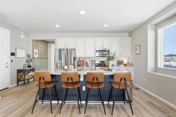 a dining hall with stainless steel appliances granite countertop a dining table and chairs