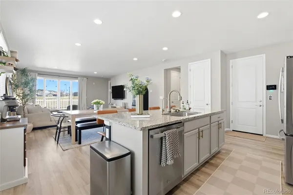 a view of a kitchen with kitchen island stainless steel appliances a table and chairs