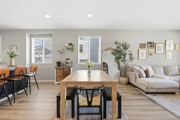 a living room with furniture a potted plant and open kitchen view