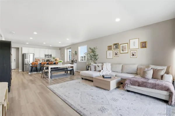 a living room with furniture and view of kitchen