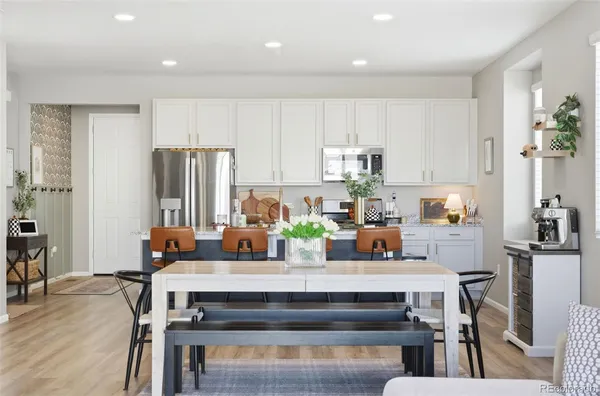a kitchen with a table chairs refrigerator and microwave