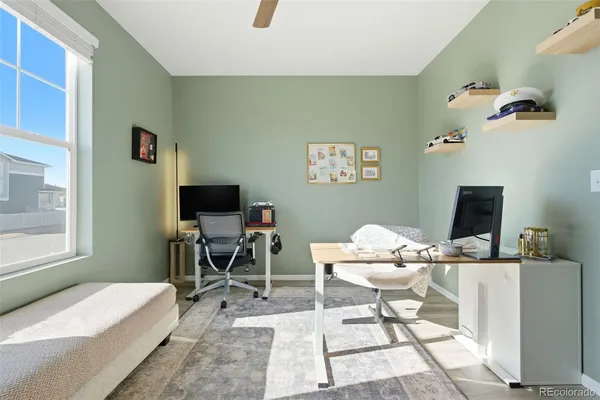 a work room with furniture a flat screen tv and a window