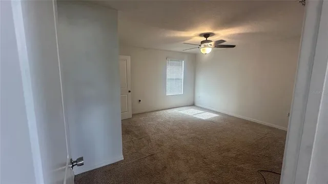 a view of a livingroom with a ceiling fan and window