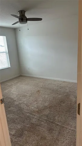 a view of a livingroom with a ceiling fan and window