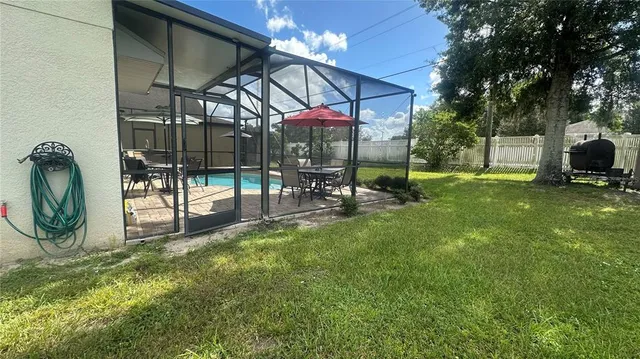 a view of a backyard with table and chairs under an umbrella