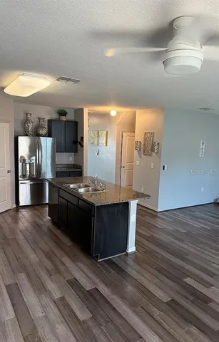 a large kitchen with stainless steel appliances kitchen island granite countertop a large counter top and wooden floors