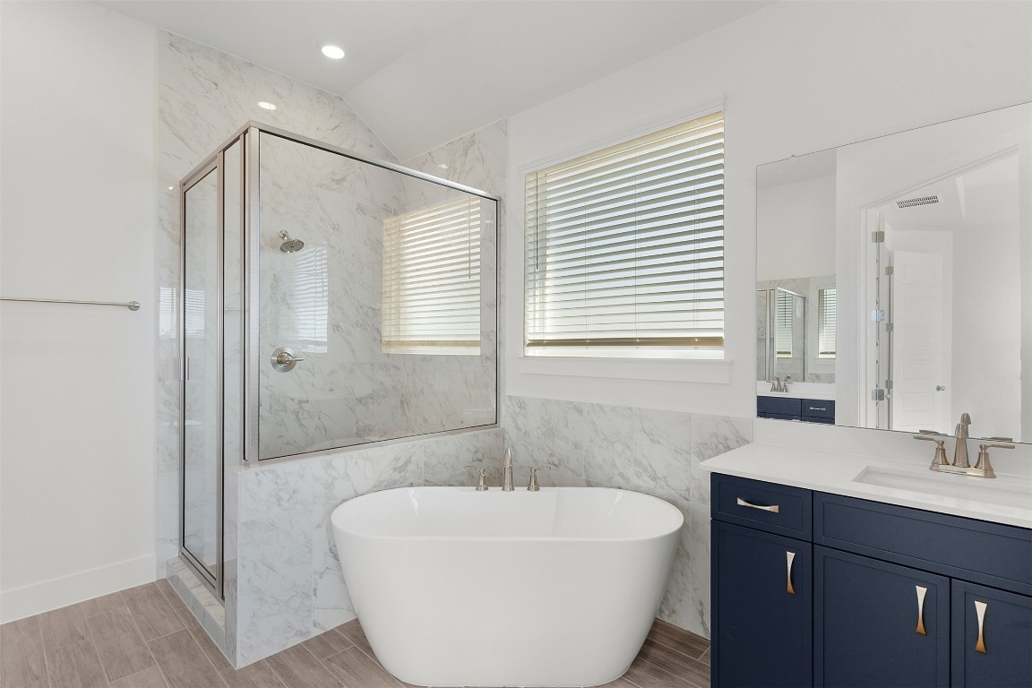 333 Ridgewell Loop Georgetown, TX 78633 - Photo 12 of 29 Bathroom featuring a soaking tub, a marble finish shower, vanity, wood finish floors, and recessed lighting